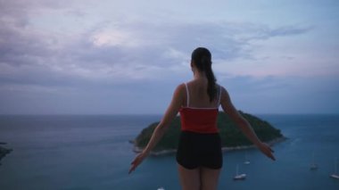 Kadın pratik yoga fitness egzersiz yüksek yere Adası'nın muhteşem manzaralı güneş doğarken