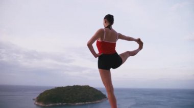 Kadın pratik yoga fitness egzersiz yüksek yere Adası'nın muhteşem manzaralı güneş doğarken