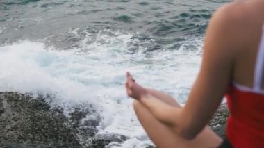 Pratik yoga fitness egzersiz fırtınalı okyanus önünde kayalık plaj sakin kadın