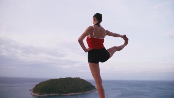 Kadın pratik yoga fitness egzersiz yüksek yere Adası'nın muhteşem manzaralı güneş doğarken — Stok video