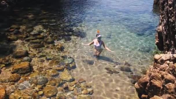 Jeune femme plongée avec tuba dans l'eau tropicale bleue portant un maillot de bain blanc — Video