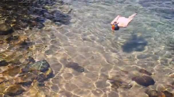 Девушка ныряет с маской в голубой тропической воде в белых купальниках — стоковое видео