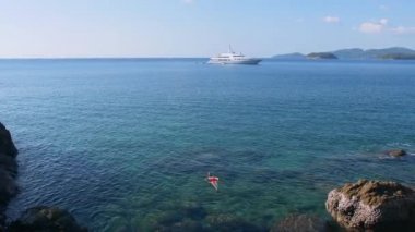 Genç kadın ile kırmızı mayo giyiyor mavi tropikal su içinde şnorkel gemisi ufuktan. Seyahat kavramı