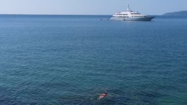 Genç kadın ile kırmızı mayo giyiyor mavi tropikal su içinde şnorkel gemisi ufuktan. Seyahat kavramı