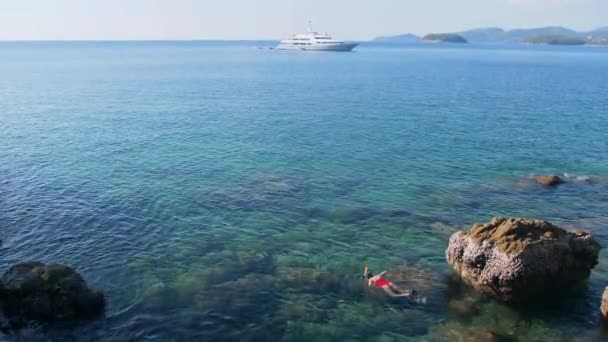 年轻女子穿着红色泳衣 在地平线上与游船浮潜在蓝色的热带水域 旅游理念 — 图库视频影像