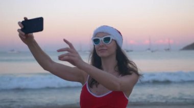 Tropikal plaj tatil selfie fotoğrafta kırmızı santa şapka eğlenceli kadın
