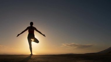 Yoga fitness exersice deniz Plajı'nda sunrise yapıyor kadın siluet