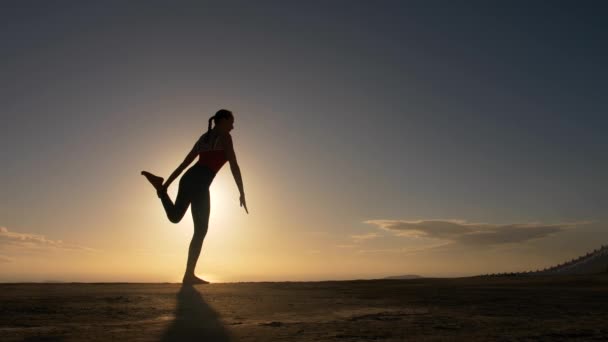 Silueta de mujer haciendo ejercicios de yoga en la playa de mar al amanecer — Vídeos de Stock