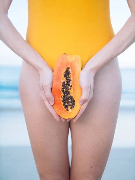 Kadın vajina gün batımında sahilde olarak egzotik meyve papaya ile sarı mayo