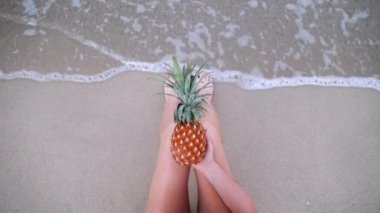 Üstten Görünüm ananas kumsalda seksi bacaklar tutan kadının kendini vurdu