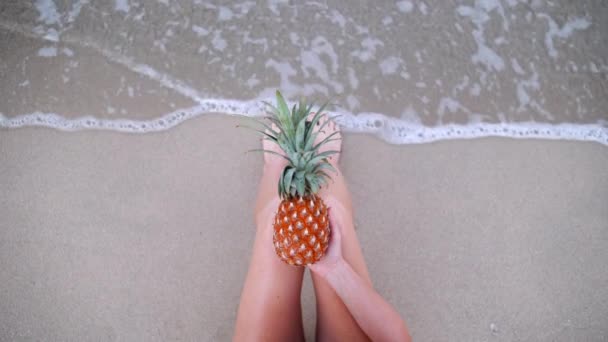 妇女拿着菠萝性感的腿在海滩自己射击的最高视图 — 图库视频影像