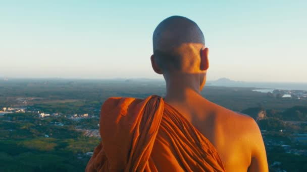 Провинция Краби, Таиланд CIRCA 2019. Буддийские монахи с видом на пейзаж возле статуи Будды на вершине Тигриной пещеры Храм Ват Тхэм Суэа — стоковое видео