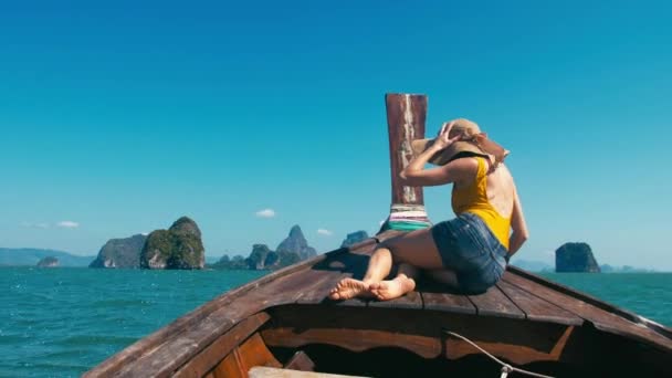 Mujer joven sentada en la parte delantera del bote de cola larga en el Parque Nacional de la Bahía de Phang Nga, Asia, Tailandia — Vídeo de stock