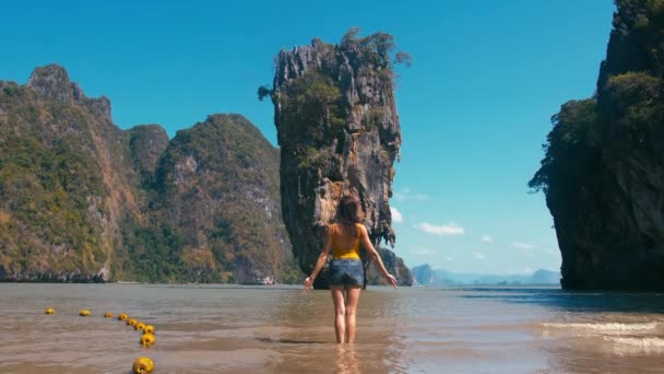 Woman doing yoga in front of famous tourist landmark James Bond island in Thailand