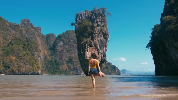 Frau macht Yoga vor berühmtem Touristendenkmal James Bond Island in Thailand — Stockvideo