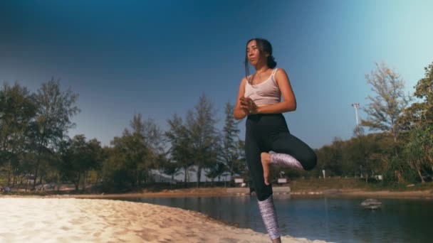 Азиатка практикует йогу фитнес-упражнения на пляже. Здоровый образ жизни — стоковое видео