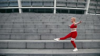 Jimnastik yaparken kadın giyiyor kırmızı spor giyim gülümseyen karışık yarış sarışın