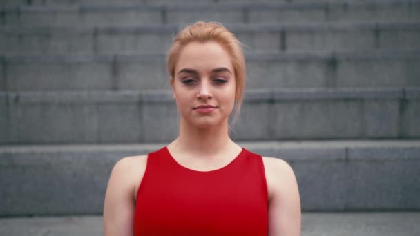 Portret van plus grootte gemengd ras blonde vrouw draagt rode sportkleding camera kijken — Stockvideo