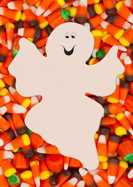 Halloween candy corn with candy pumpkins background with spooky ghost for your message