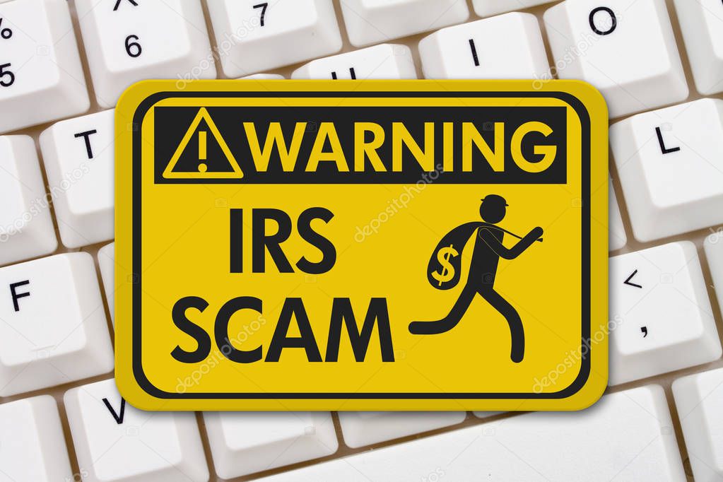 Tax scam warning sign, A yellow warning sign with text IRS Scam and theft icon on a keyboard