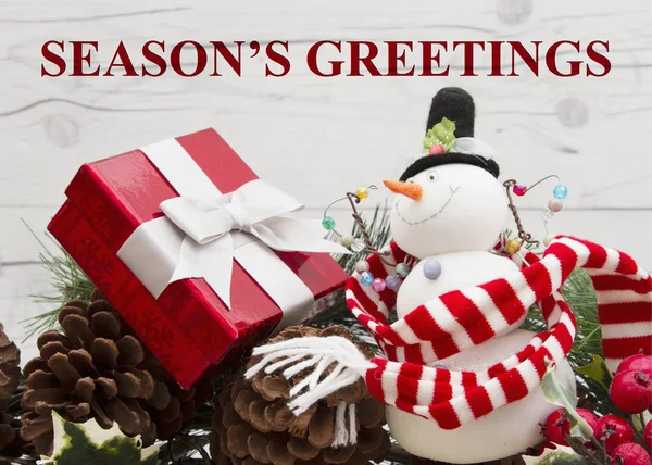 老时尚圣诞问候 加兰与雪人 松果和红色冬青浆果风化的木材背景与文字季节的问候 — 图库照片