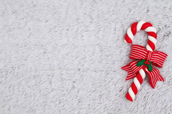 クリスマスのためのあなたのメッセージのためにモックアップとして使用できますぬいぐるみの灰色素材の背景にキャンディ ケーン — ストック写真