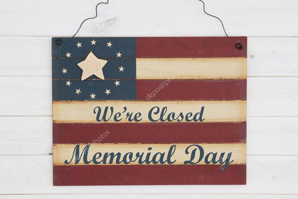 We are closed Memorial Day text on a retro wood American stars and strip flag sign on weathered wood