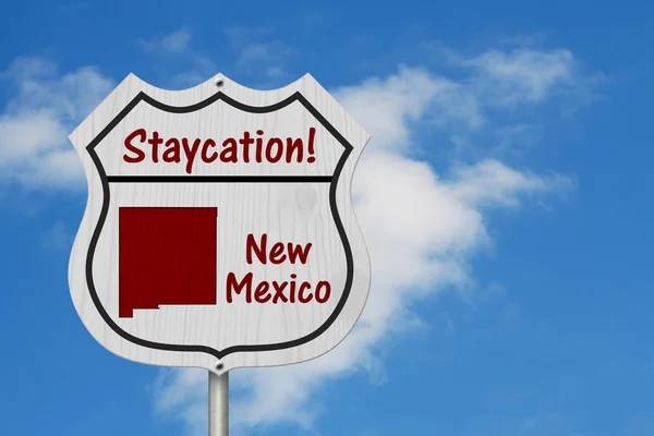 New Mexico Staycation Highway Sign, New Mexico map and text Staycation on a highway sign with sky background