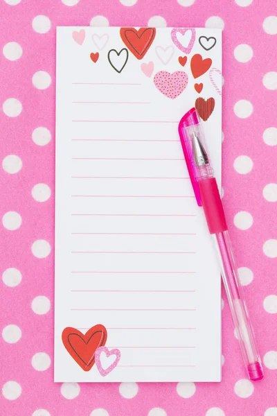 心脏记事本与笔在明亮的粉红色和白色波尔卡点织物与复制空间为您的消息 — 图库照片