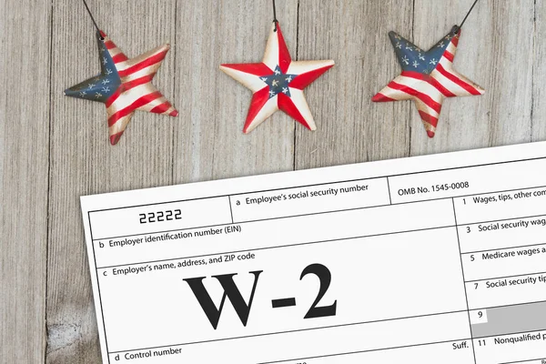 A US Federal tax W2 income tax form on weathered wood with USA stars