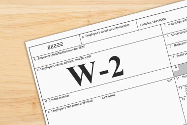 A US Federal tax W2 income tax form on a desk clipart