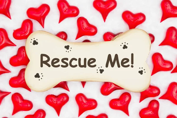 Rescue me message on a wood dog bone with paw print with red hea — Stock Photo, Image