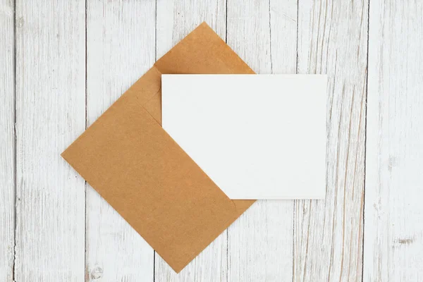 Lege envelop met wenskaart op verweerde whitewash textuur — Stockfoto