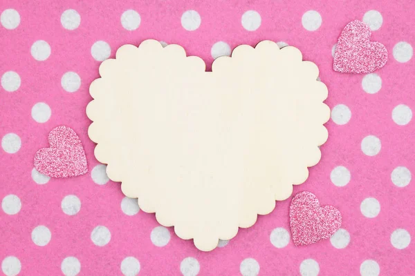 Corazón de madera en blanco sobre tela de lunares rosa y blanca con purpurina — Foto de Stock