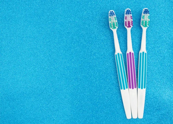 Cepillos de dientes sobre fondo de purpurina azul —  Fotos de Stock