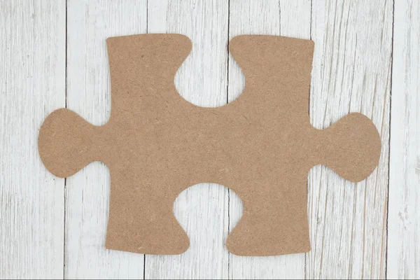Kawałek tektury puzzle na wyblakły wybielić teksturowanej drewniane oparcie — Zdjęcie stockowe