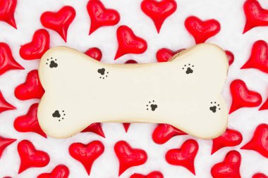 Wood dog bone with paw print with red hearts on white fabric bac clipart