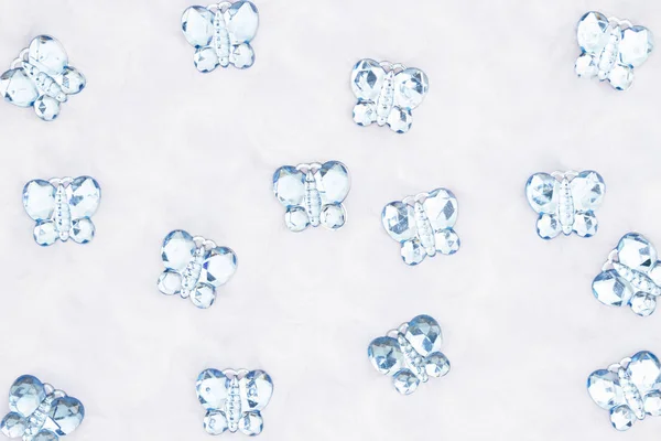 Blue glass butterflies on white fabric background — Stock Photo, Image