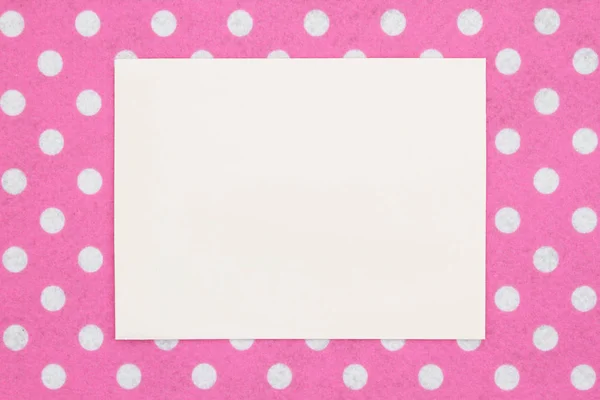Leere beige Grußkarte auf rosa und weißem Tupfen — Stockfoto