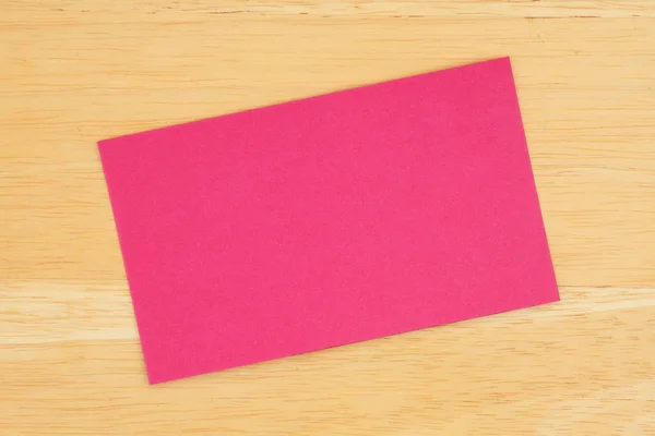 Cartão de saudação em branco rosa no fundo de madeira texturizada — Fotografia de Stock