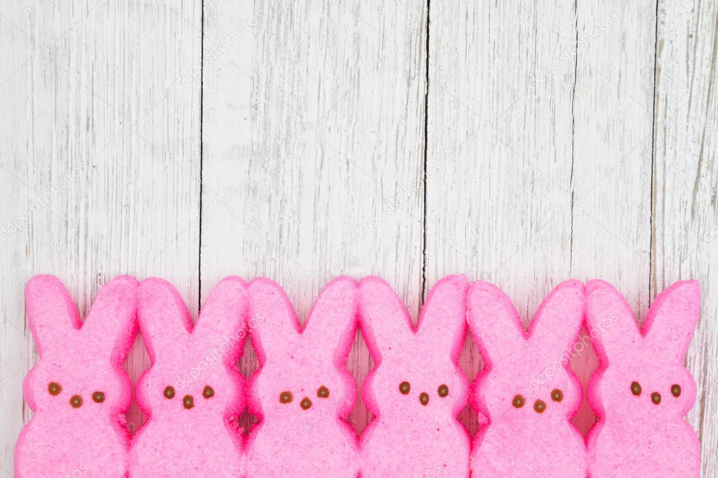 Pink candy bunnies on weathered whitewash textured wood backgrou