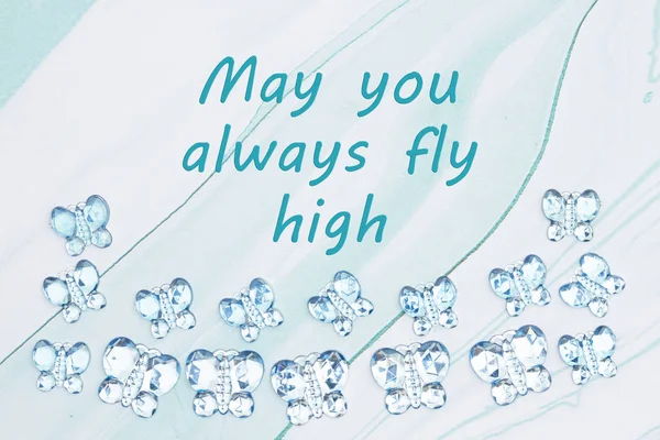 May you always fly high message with blue glass butterflies on b — Stock Photo, Image