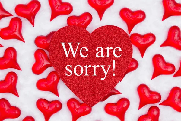 We are sorry message on glitter heart with red hearts on white f — Stock Photo, Image