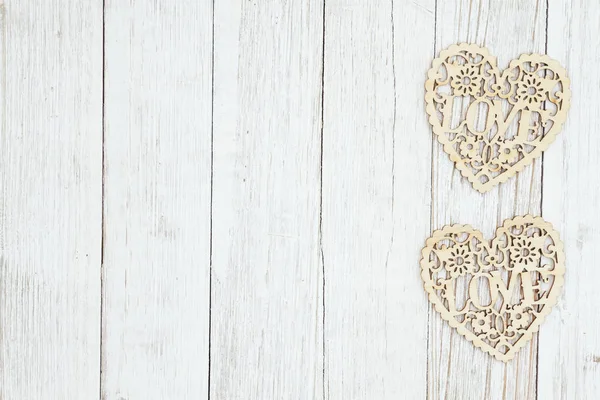 Дерев'яні серця на вивітрюваному побілки текстурованого дерев'яного фону — стокове фото