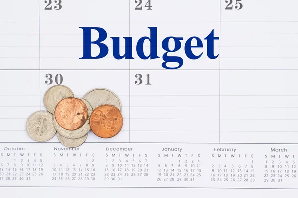Begroting van het bericht van uw geld op een maandkalender met munten — Stockfoto