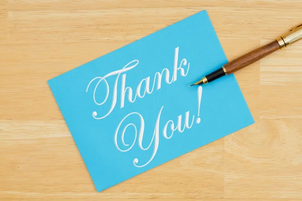 Obrigado cartão de saudação azul com uma caneta em madeira texturizada — Fotografia de Stock