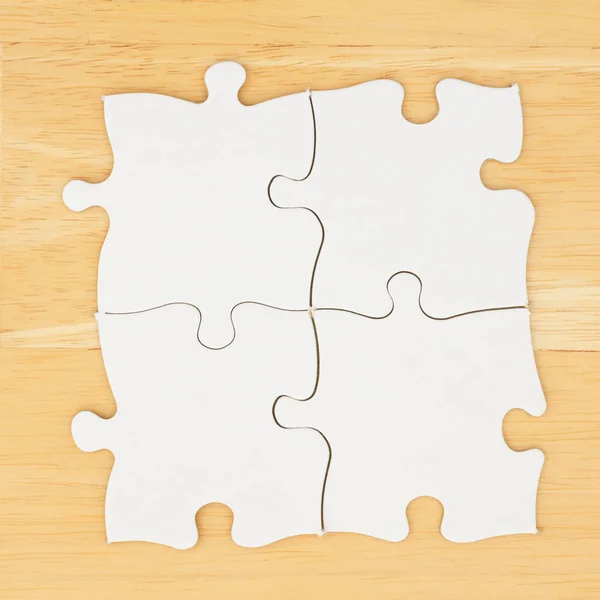 Dokulu masa ahşap arka planda dört boş puzzle parçaları — Stok fotoğraf