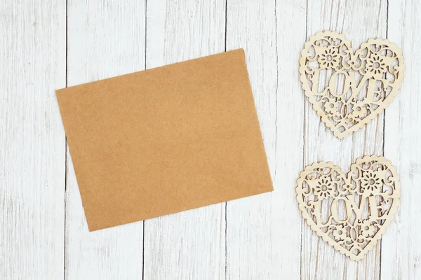 Κενή ευχετήρια κάρτα με καρδιές ξύλου σε διαβρωμένη κείμενο με ασβέστη — Φωτογραφία Αρχείου