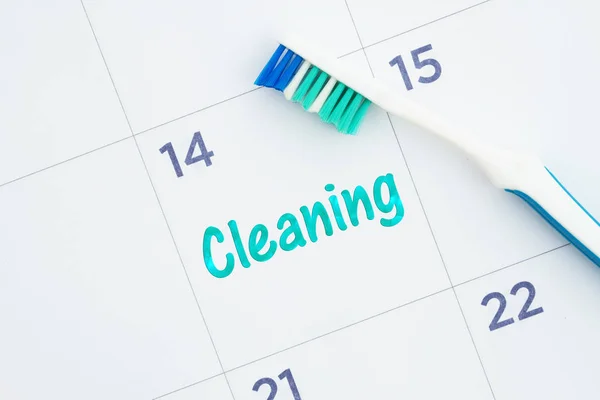 Pianificare un messaggio di pulizia dentale su un calendario con uno spazzolino da denti — Foto Stock
