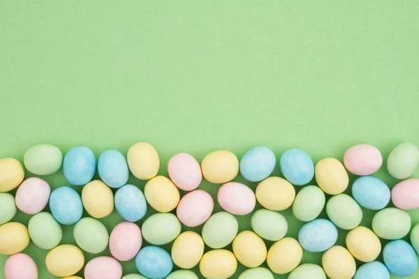 Candy Velikonoční vaječné pozadí zelený papír — Stock fotografie